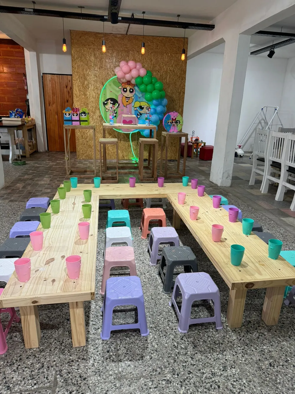 Mesas de madera con banquitos de colores para un cumple infantil, El Arca Salón